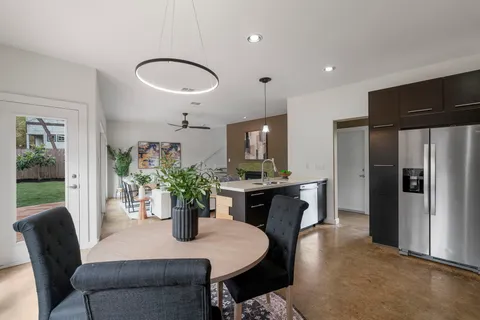 a dining room with furniture potted plants and wooden floor