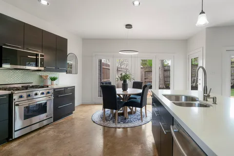 a kitchen with kitchen island granite countertop a stove and a sink