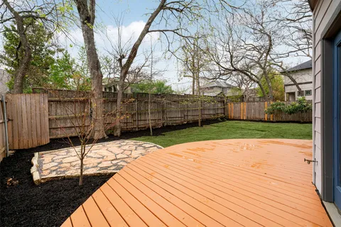 a view of a backyard with wooden fence