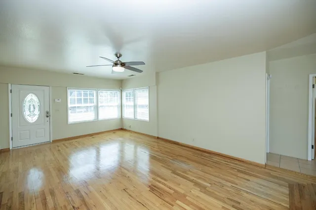 a view of a hallway with wooden floor windows and chandelier