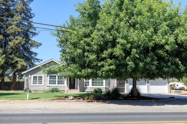a front view of a house with a yard and green space