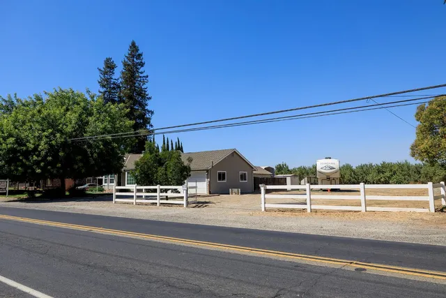a front view of a house with a yard and trees