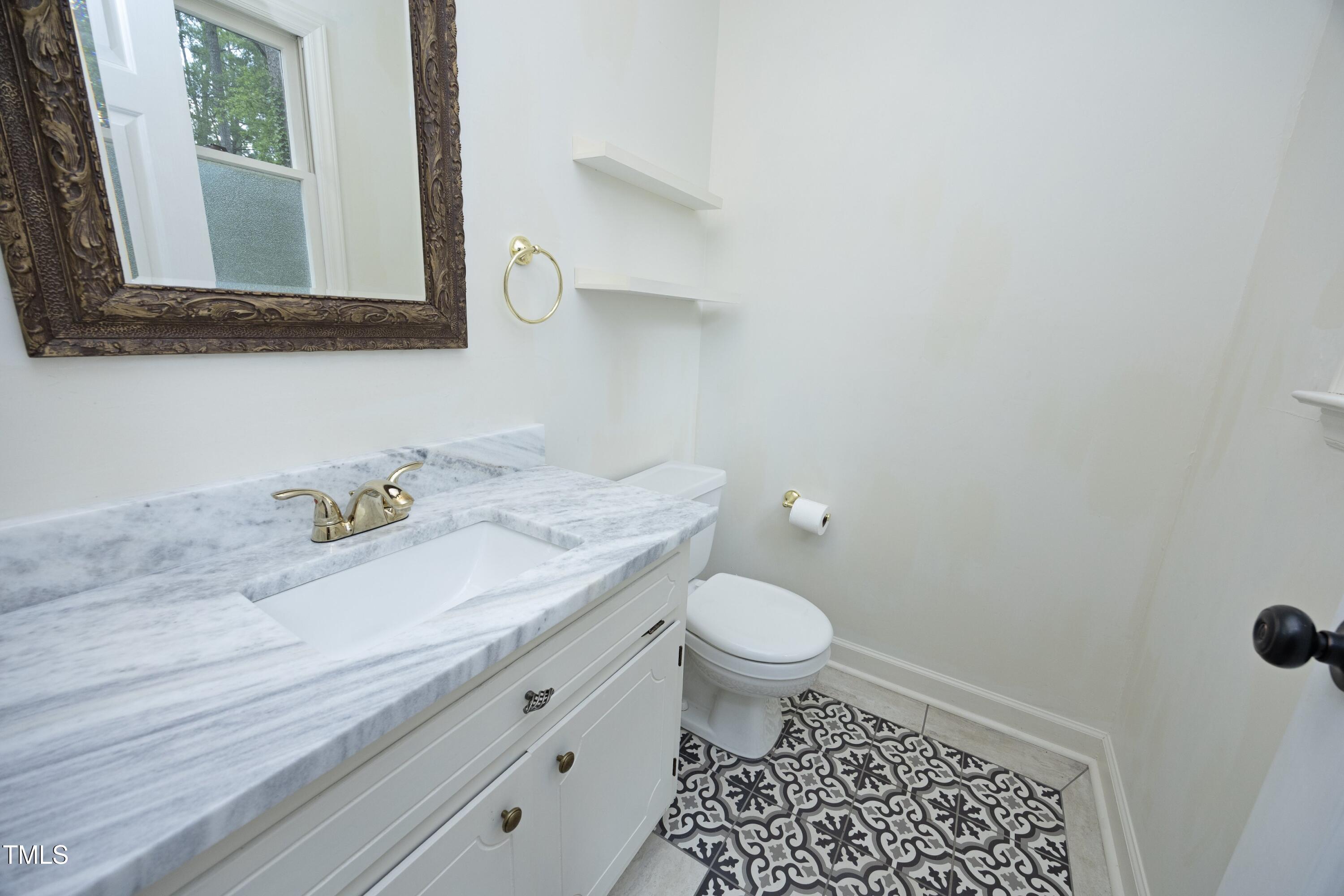 409 Glaive Drive Durham, NC 27703 - Photo 19 of 35 a bathroom with a sink a toilet and a mirror