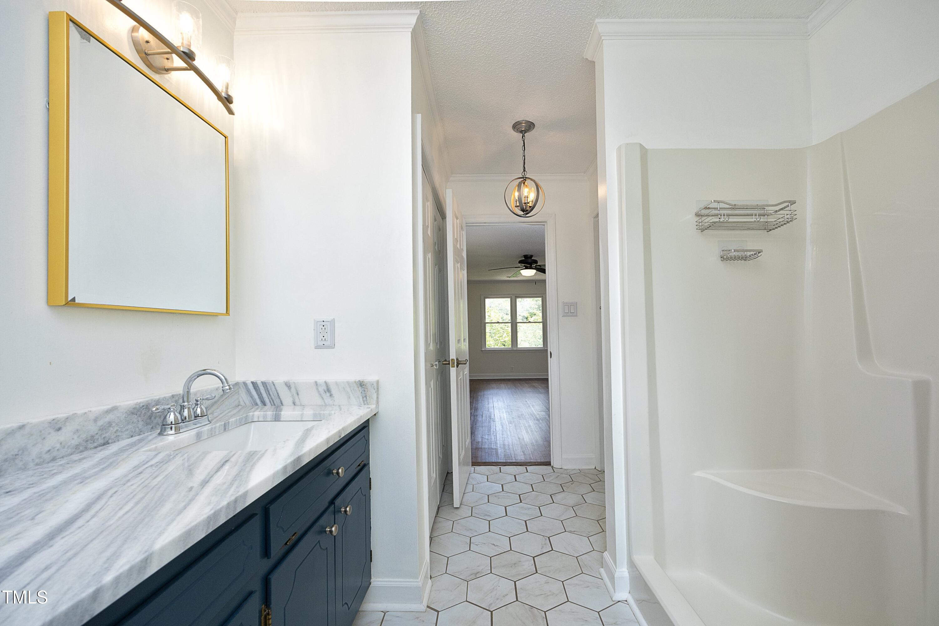 409 Glaive Drive Durham, NC 27703 - Photo 23 of 35 a bathroom with a granite countertop sink and a mirror