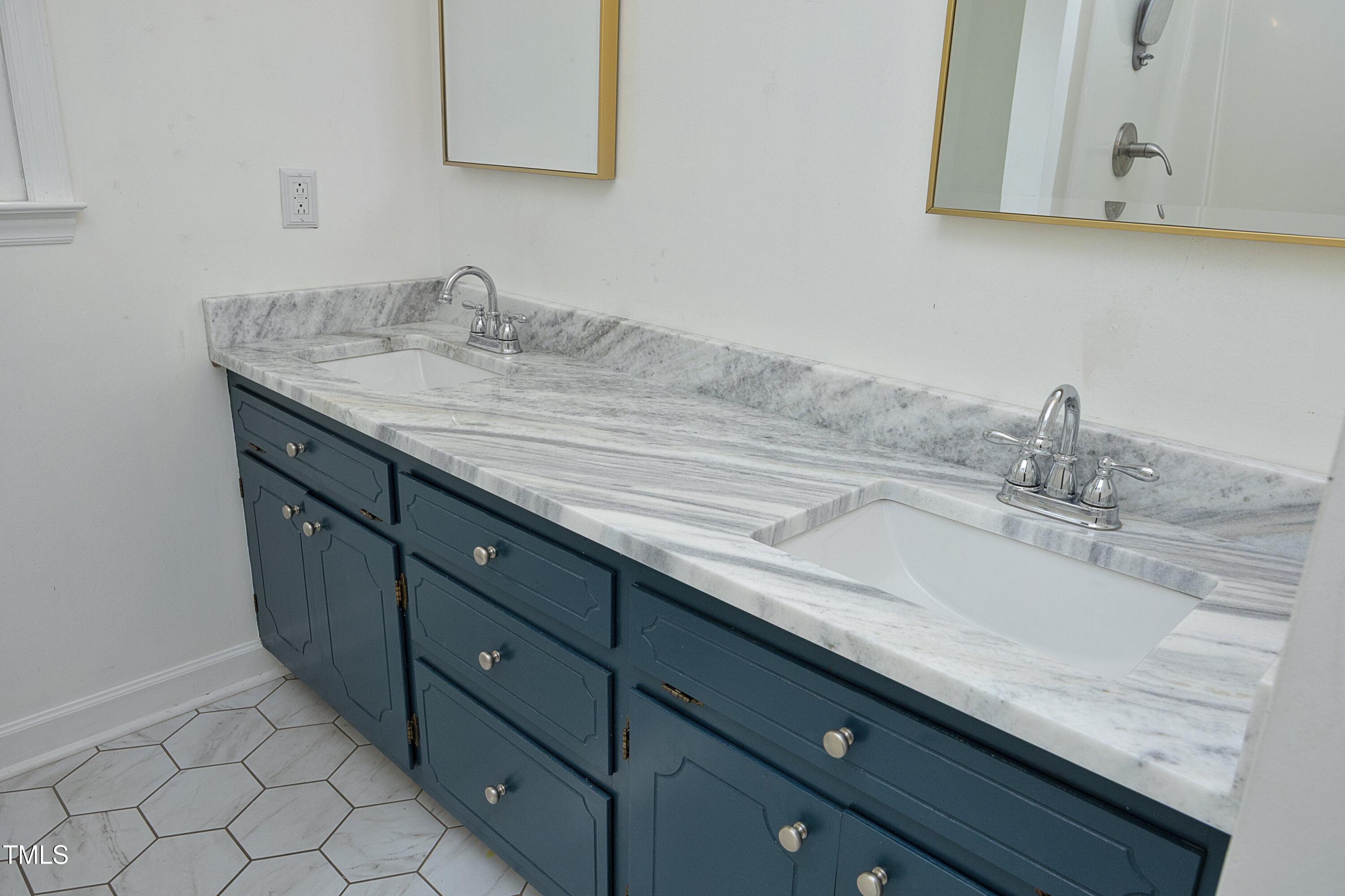 409 Glaive Drive Durham, NC 27703 - Photo 24 of 35 a bathroom with a granite countertop sink and a mirror
