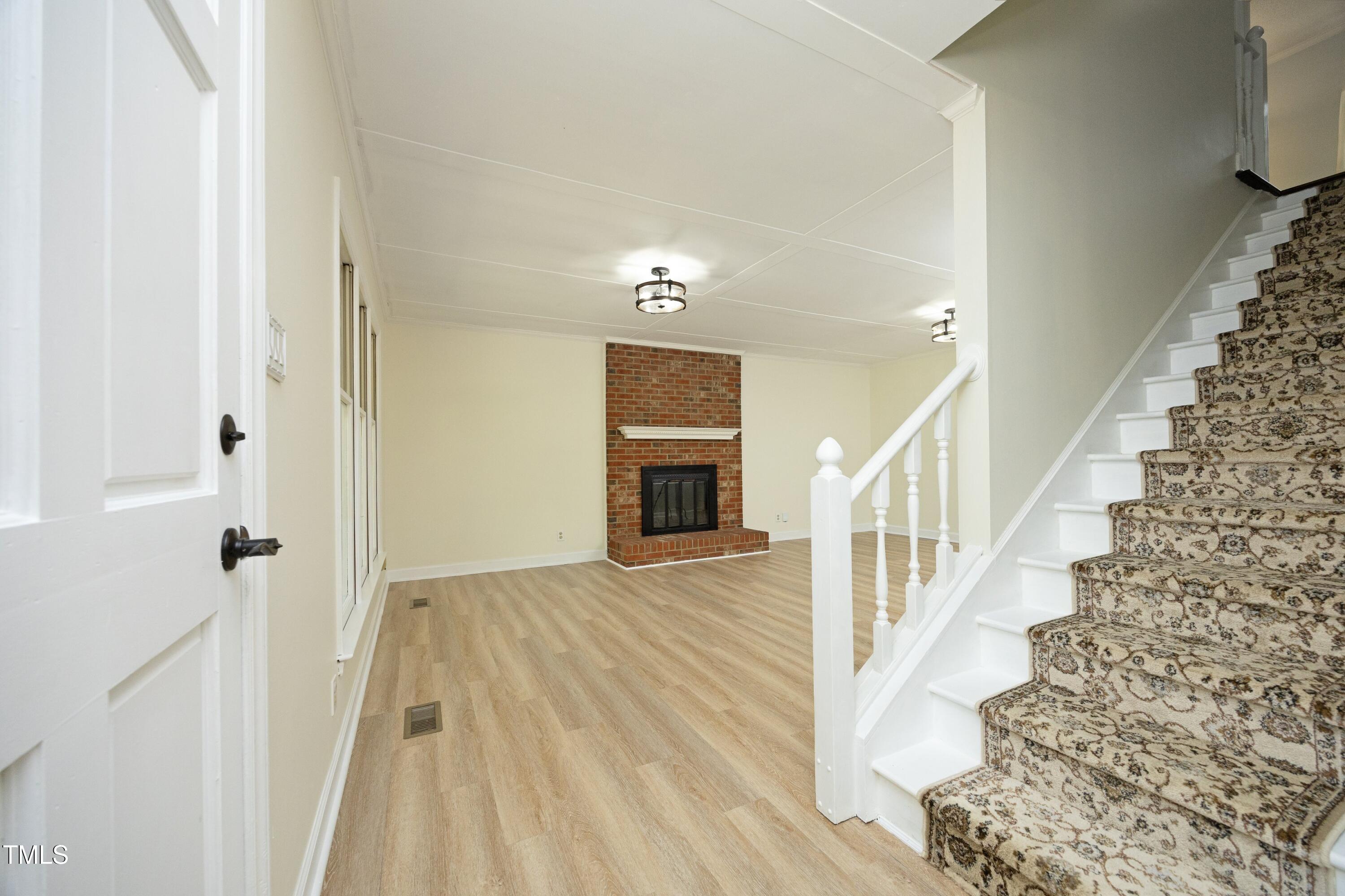 409 Glaive Drive Durham, NC 27703 - Photo 3 of 35 a view of a hallway with wooden floor and staircase