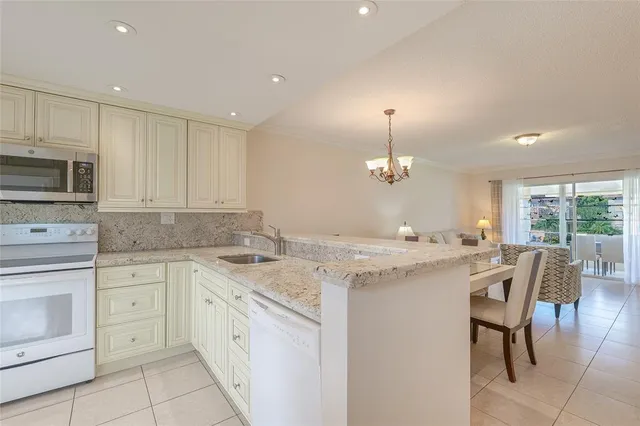 a kitchen with granite countertop white cabinets stainless steel appliances and a sink