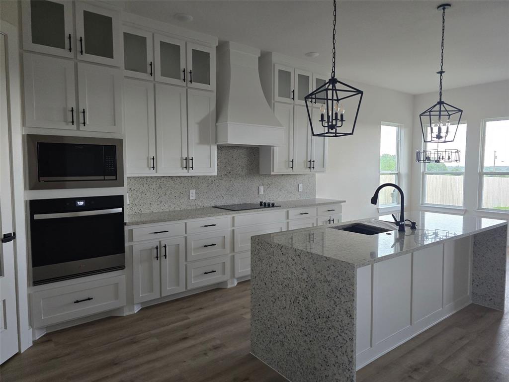 808 N Avenue East Springtown, TX 76082 - Photo 5 of 21 a kitchen with stainless steel appliances granite countertop a stove a sink and a microwave