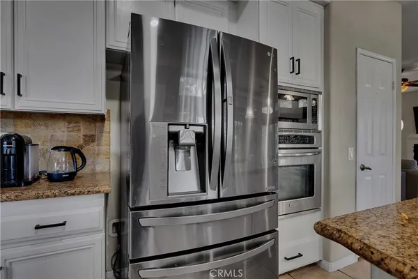 a kitchen with white cabinets and appliances