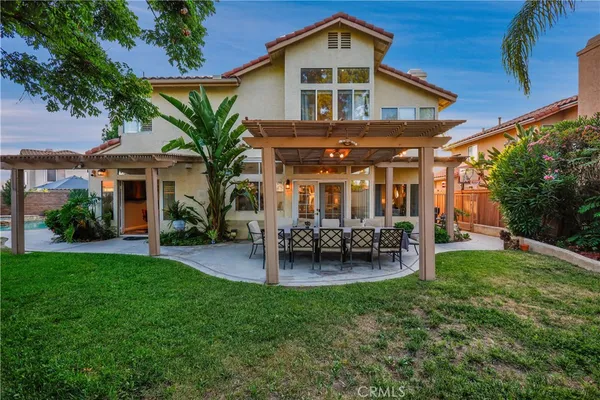 a view of house with a big yard and potted plants