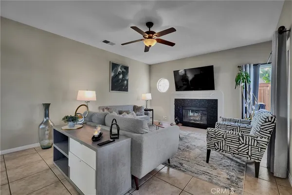 a living room with furniture a flat screen tv and a fireplace