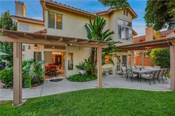 a view of a chair and table in backyard of the house