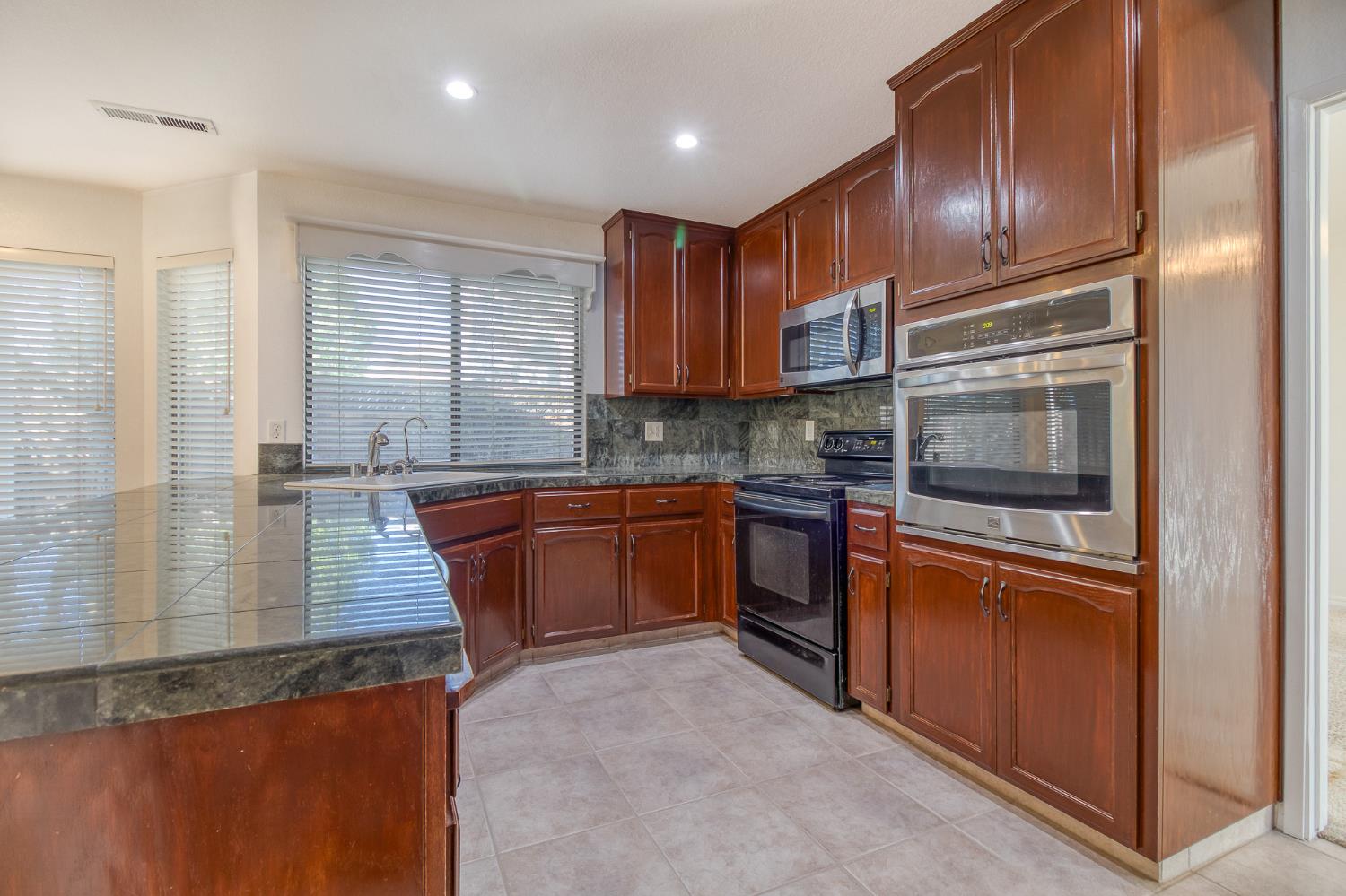 4209 Godfrey Drive Salida, CA 95368 - Photo 11 of 34 a kitchen with granite countertop stainless steel appliances and wooden cabinets
