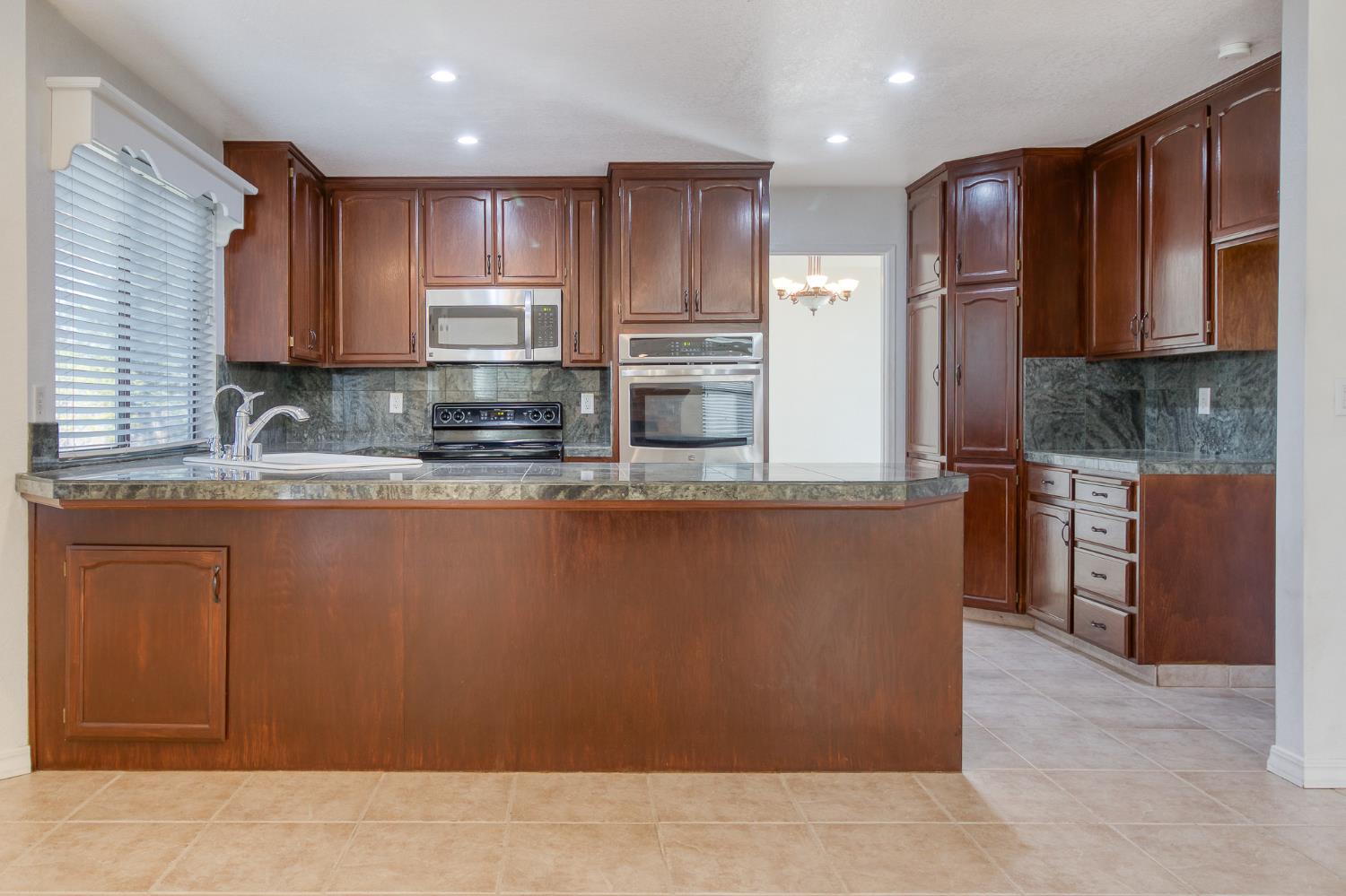 4209 Godfrey Drive Salida, CA 95368 - Photo 14 of 34 a kitchen with stainless steel appliances granite countertop a refrigerator a stove a sink and a microwave