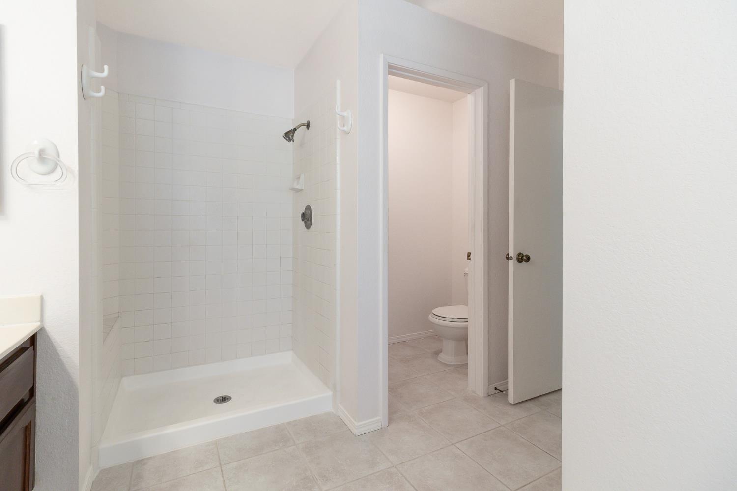 4209 Godfrey Drive Salida, CA 95368 - Photo 25 of 34 a bathroom with a granite countertop toilet and a shower