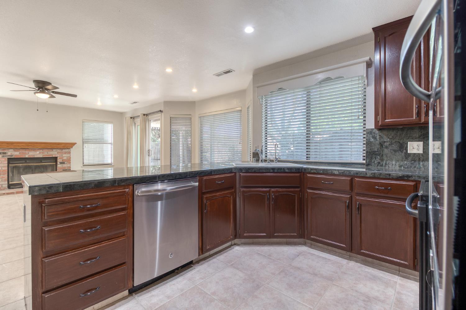 4209 Godfrey Drive Salida, CA 95368 - Photo 10 of 34 a kitchen with granite countertop a sink and dishwasher a oven with wooden cabinets