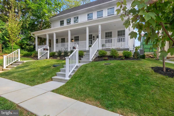 a front view of a house with a yard and green space