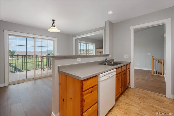 a kitchen with stainless steel appliances granite countertop a stove a sink and a refrigerator with wooden floor