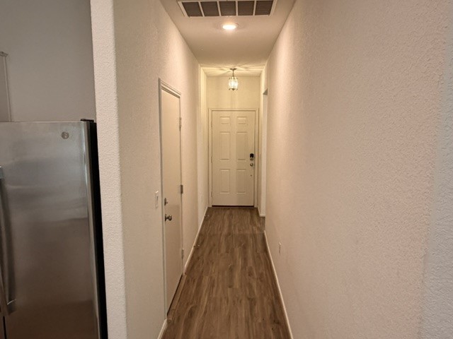 6917 Colorado Bluffs Road Austin, TX 78744 - Photo 10 of 19 a view of a hallway with wooden floor and a bathroom