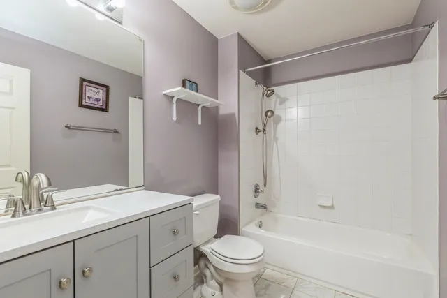 a bathroom with a granite countertop sink a toilet and shower