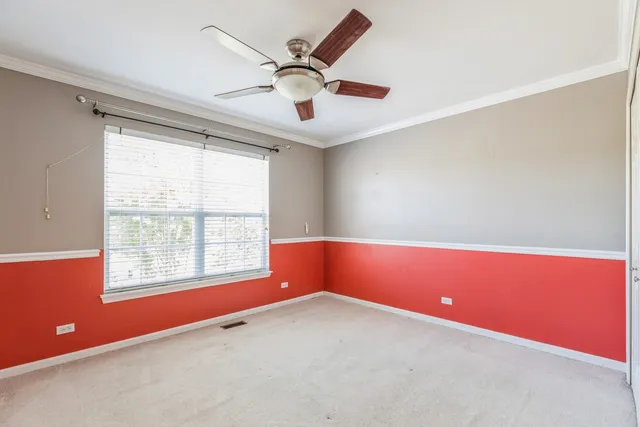 an empty room with windows and ceiling fan