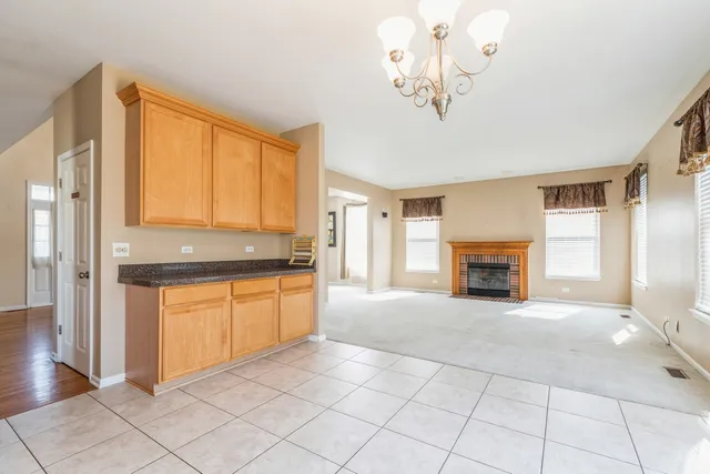 a view of an empty room with a fireplace and a window