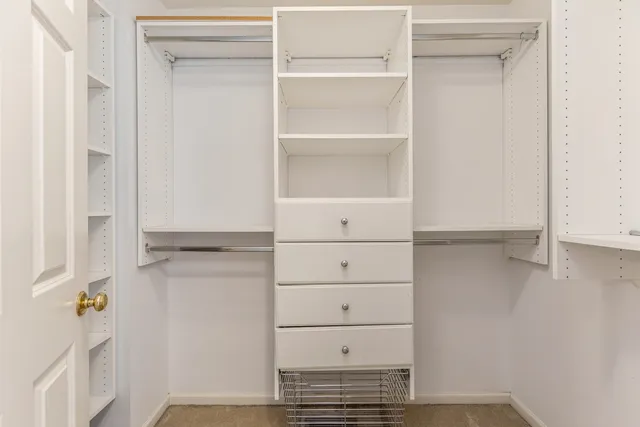a view of walk in closet with empty racks