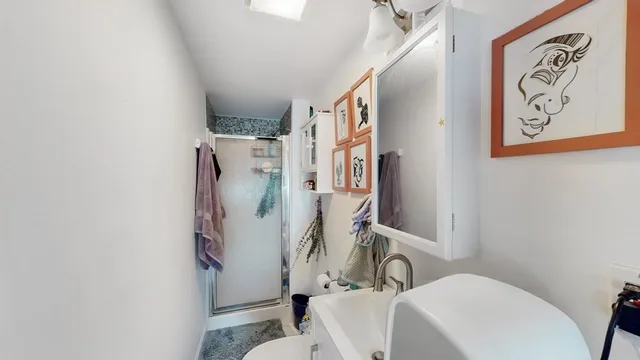 a bathroom with a sink a toilet and shower