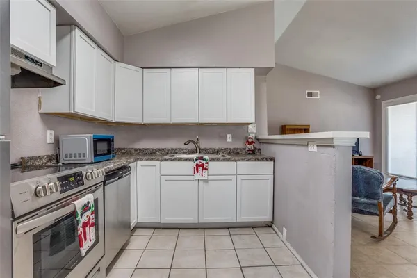 a kitchen with a stove top oven and cabinets