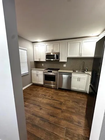 a kitchen with stainless steel appliances a stove a sink and a refrigerator