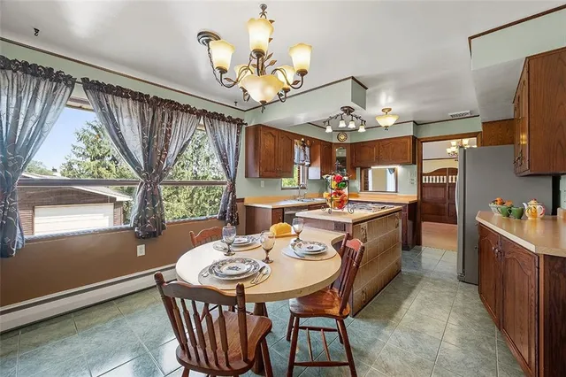 a view of a dining room with furniture a chandelier and large windows