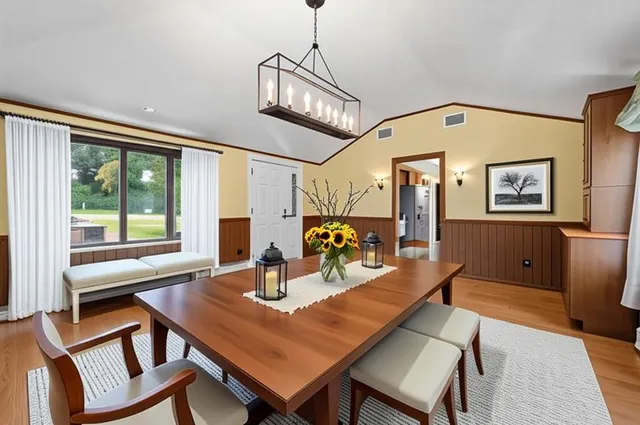 a view of a dining room with furniture a chandelier and wooden floor
