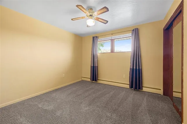 an empty room with closet and a chandelier fan