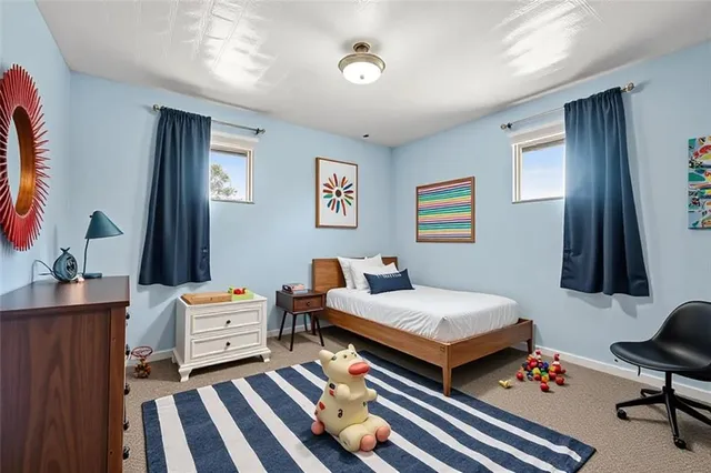 a bedroom with a bed and a lamp on dresser