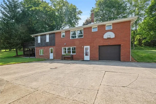 a view of house with backyard space and tree
