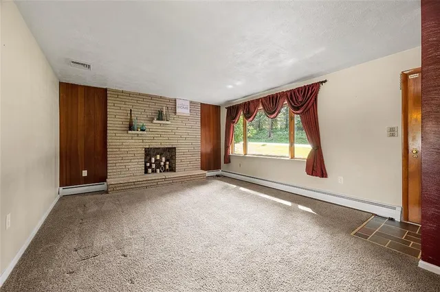 an empty room with fireplace and windows