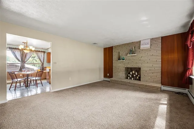 an empty room with windows and fireplace