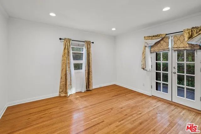 a view of empty room with wooden floor and floor to ceiling window