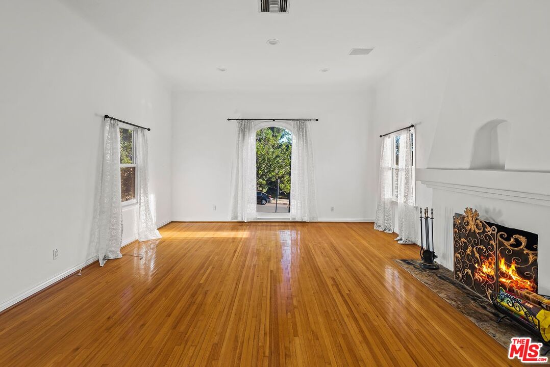 10497 Kinnard Avenue Los Angeles, CA 90024 - Photo 3 of 19 an empty room with wooden floor and windows