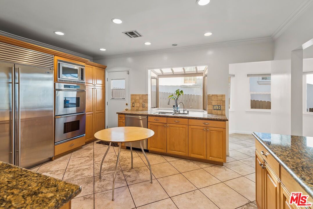 10497 Kinnard Avenue Los Angeles, CA 90024 - Photo 9 of 19 a kitchen with stainless steel appliances granite countertop a sink and a refrigerator