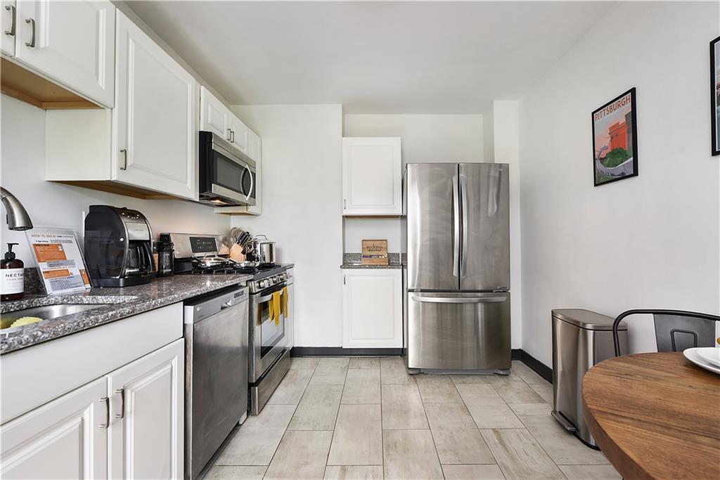 3800 Butler Street Pittsburgh, PA 15201 - Photo 18 of 21 a kitchen with stainless steel appliances granite countertop a refrigerator stove and microwave