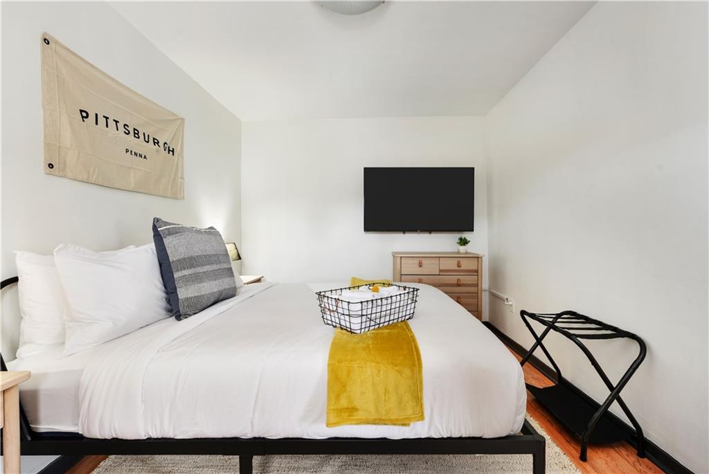 3800 Butler Street Pittsburgh, PA 15201 - Photo 19 of 21 a bedroom with a bed a couch and a flat screen tv