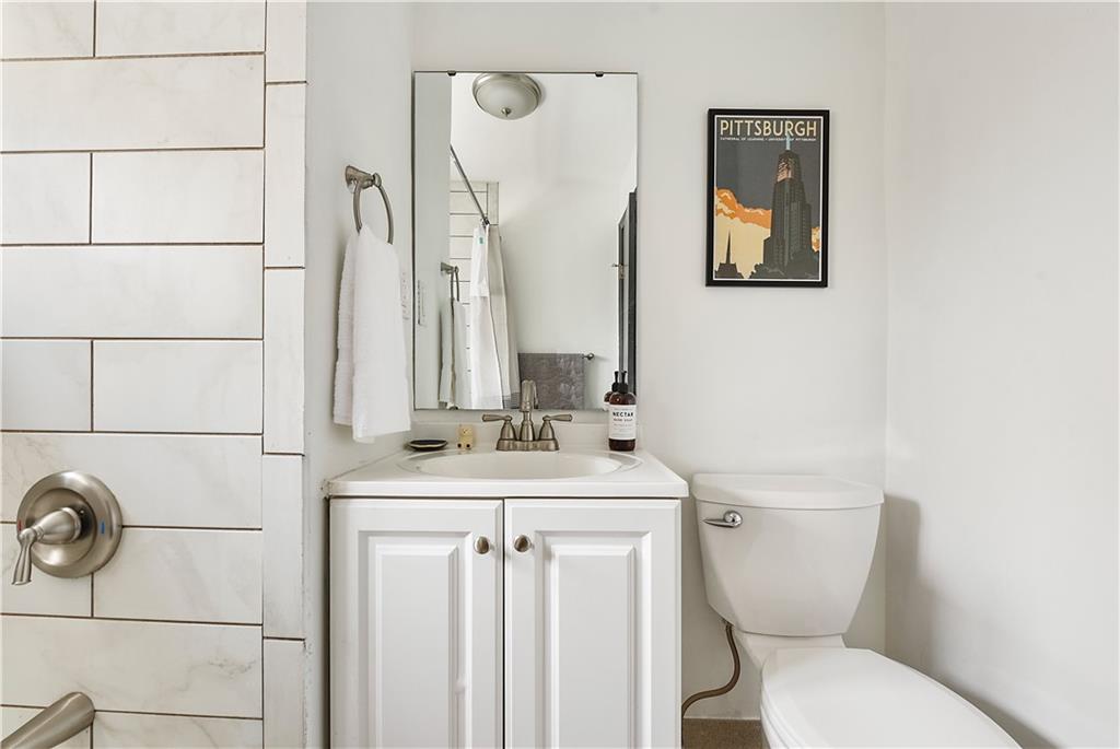 3800 Butler Street Pittsburgh, PA 15201 - Photo 21 of 21 a bathroom with a toilet sink and mirror