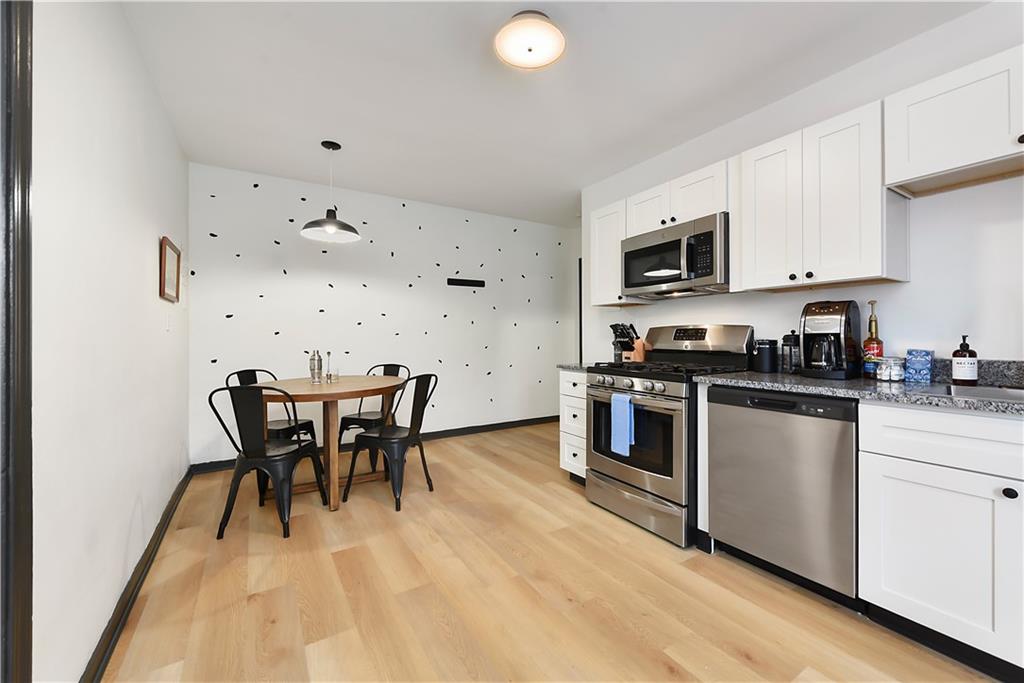 3800 Butler Street Pittsburgh, PA 15201 - Photo 9 of 21 a kitchen with stainless steel appliances a white table and chairs in it