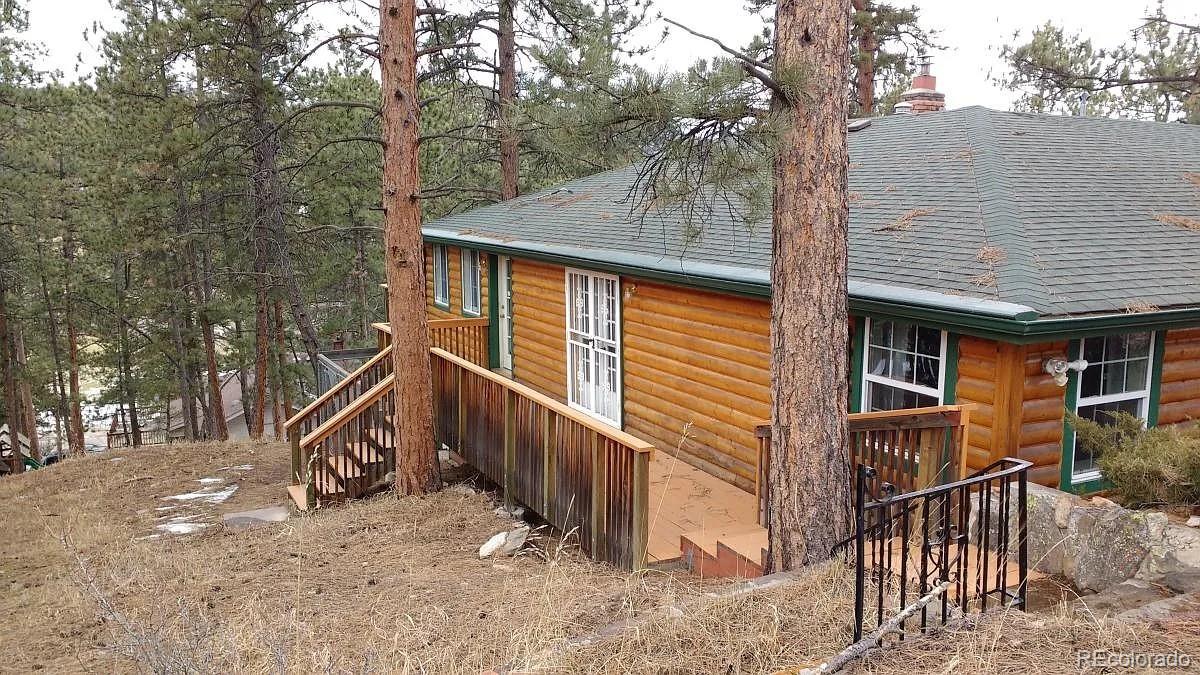 a view of house with a tree and wooden fence