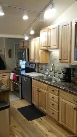 a kitchen with granite countertop a sink stainless steel appliances and cabinets