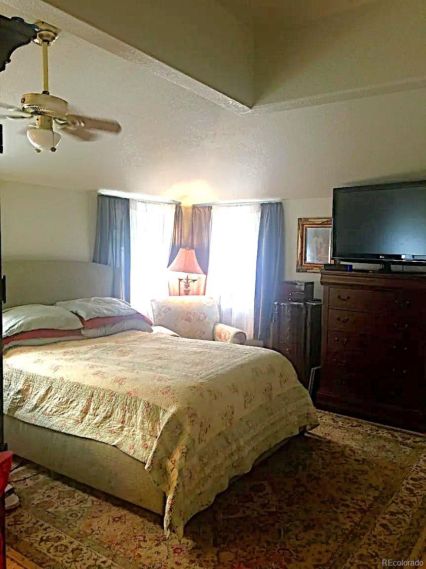 5091 South Olive Road Evergreen, CO 80439 - Photo 10 of 23 a bedroom with a bed and wooden floor