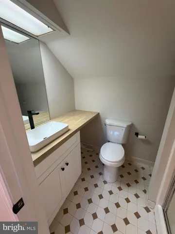 a bathroom with a toilet a sink and a mirror