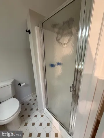 a bathroom with a glass door shower and toilet