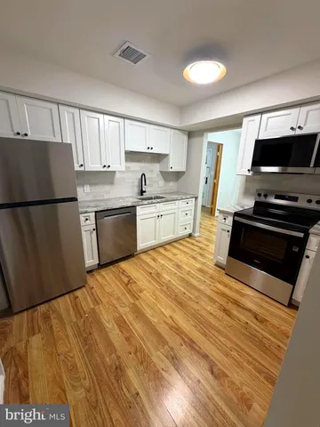 a kitchen with a refrigerator and a stove top oven